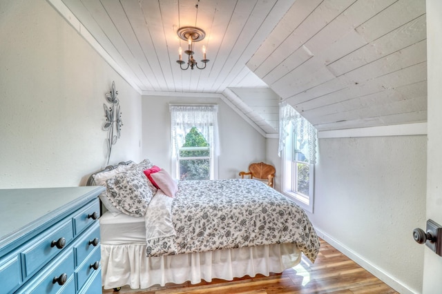 bedroom with wood ceiling, wood finished floors, baseboards, lofted ceiling, and an inviting chandelier
