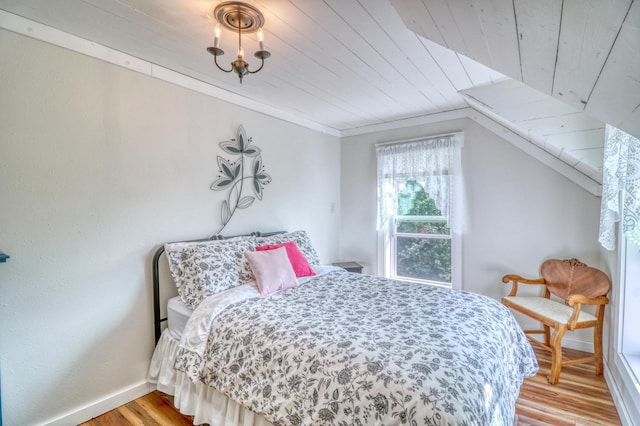 bedroom featuring wood ceiling, baseboards, and light wood finished floors