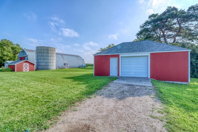 detached garage featuring dirt driveway