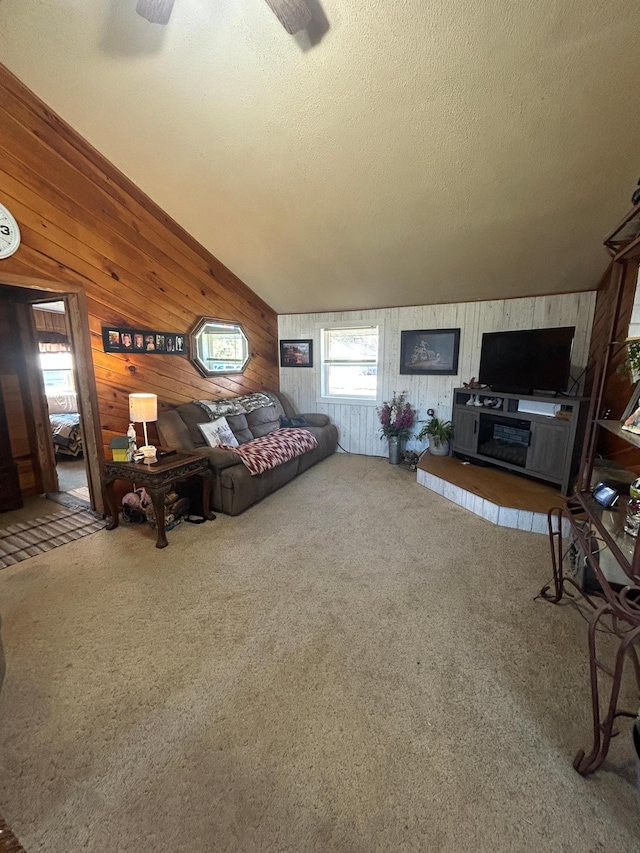 carpeted bedroom featuring wooden walls and a textured ceiling