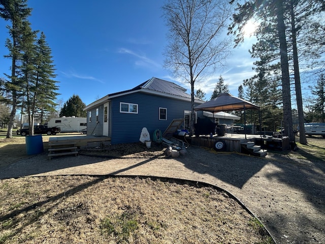 view of property exterior featuring a deck and a gazebo