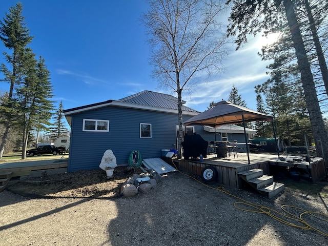 view of side of property with a gazebo and metal roof