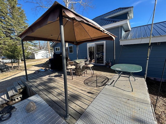 wooden deck with an outdoor structure and outdoor dining space