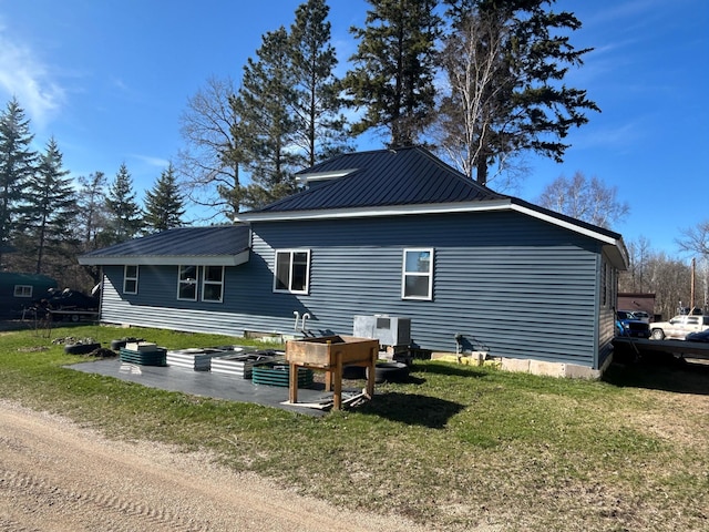 back of house with a yard and metal roof