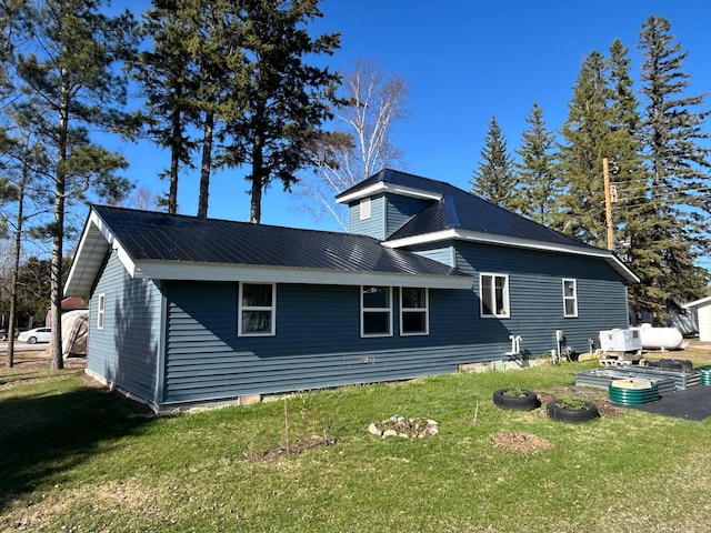 view of home's exterior featuring a lawn and metal roof