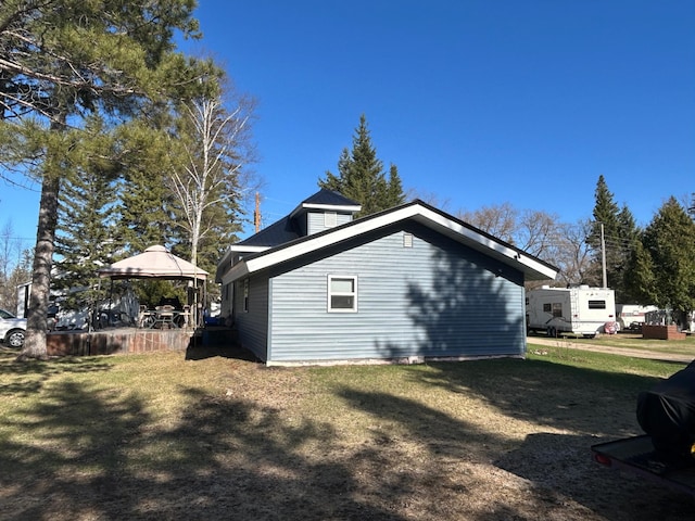 view of property exterior featuring a gazebo and a lawn