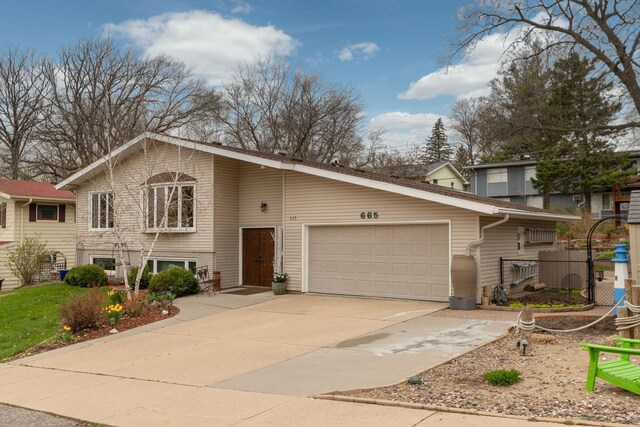 tri-level home featuring a garage and concrete driveway