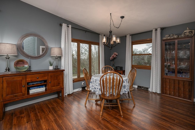 dining area with a chandelier, dark wood finished floors, vaulted ceiling, and baseboards