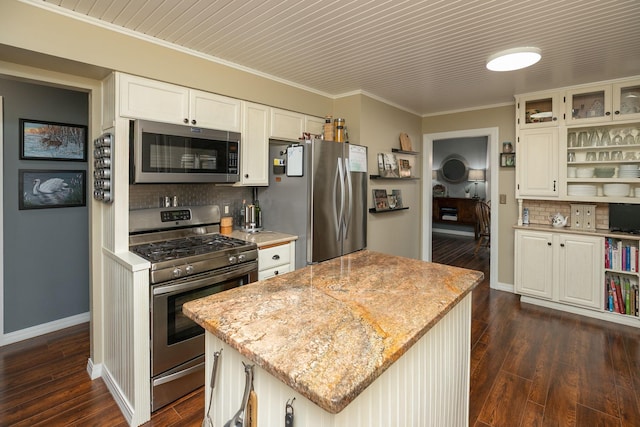 kitchen with appliances with stainless steel finishes, open shelves, tasteful backsplash, dark wood-style flooring, and a center island