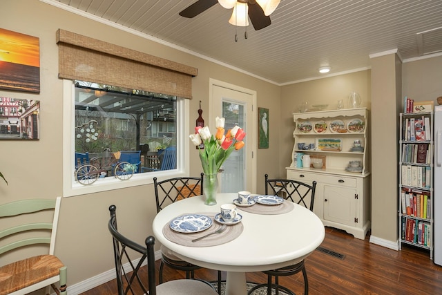 dining space featuring dark wood-style flooring, ornamental molding, baseboards, and a ceiling fan