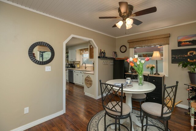 dining space with a ceiling fan, dark wood-style flooring, baseboards, and crown molding