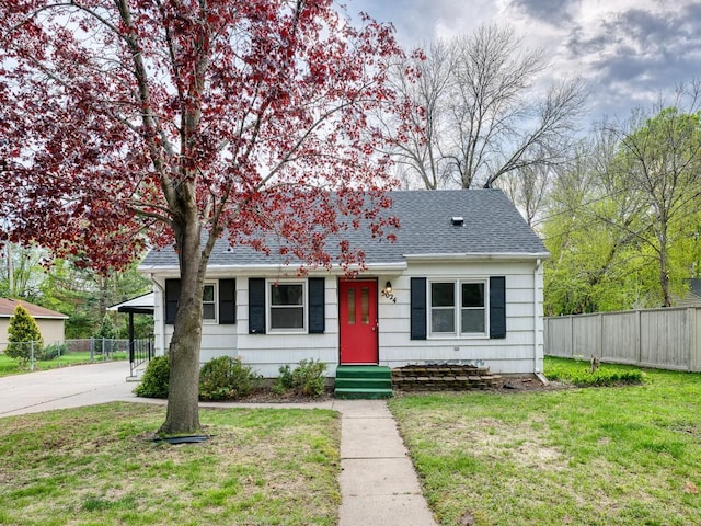 bungalow-style house featuring entry steps, a shingled roof, and driveway