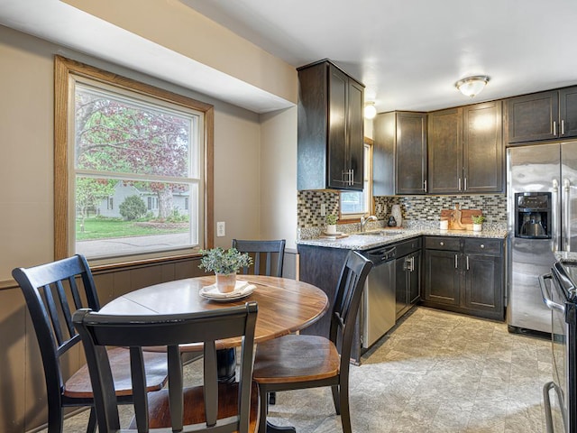 kitchen featuring stainless steel appliances, dark brown cabinetry, and backsplash