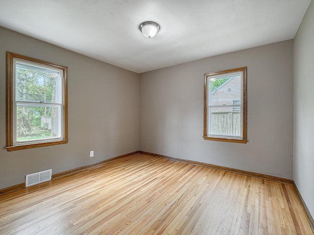 unfurnished room with light wood finished floors and baseboards