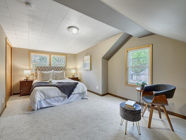 bedroom with carpet floors, baseboards, and lofted ceiling