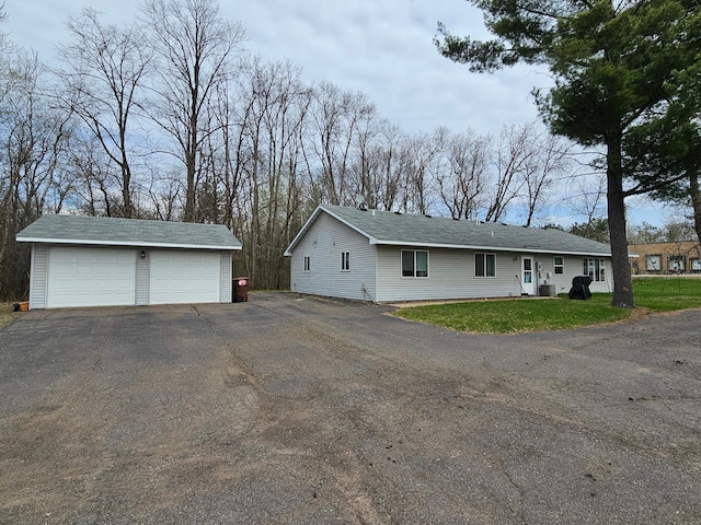 ranch-style home with a garage, an outbuilding, and a front yard