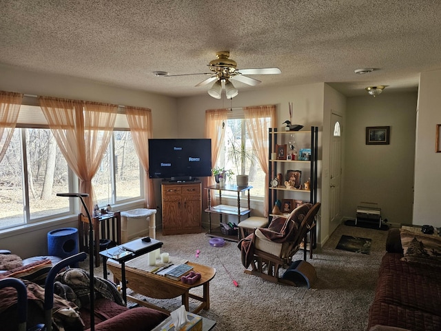 living area featuring carpet floors, a ceiling fan, and a textured ceiling