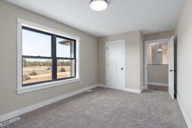 unfurnished bedroom featuring visible vents, carpet flooring, and baseboards