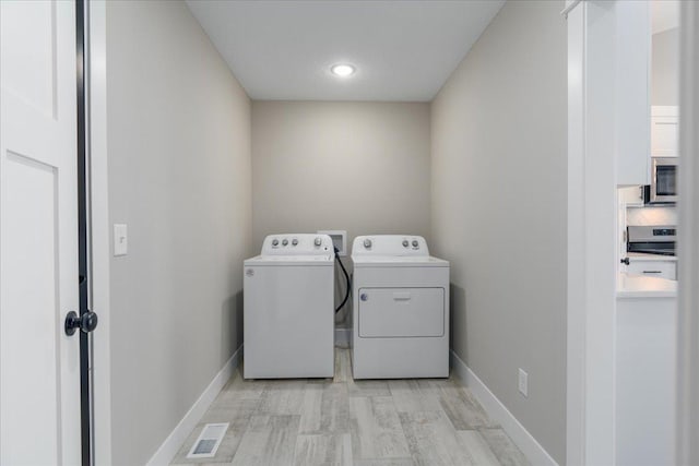 laundry area with visible vents, washer and clothes dryer, baseboards, and laundry area