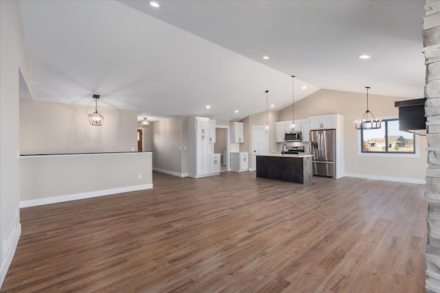unfurnished living room featuring a fireplace, wood finished floors, baseboards, lofted ceiling, and an inviting chandelier