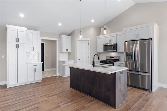 kitchen featuring a sink, lofted ceiling, tasteful backsplash, and stainless steel appliances