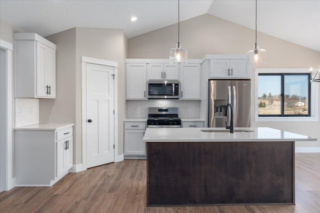 kitchen featuring light countertops, appliances with stainless steel finishes, decorative backsplash, and a sink