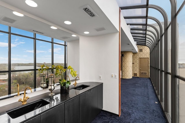 3145 Dean Ct Unit 1100, Minneapolis, MN 55416 - bar area with a sink, dark colored carpet, recessed lighting, expansive windows, and a water view