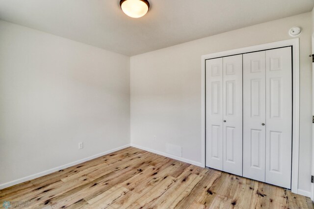 3445 18th St S, Moorhead, MN 56560 - unfurnished bedroom with baseboards, a closet, and wood finished floors
