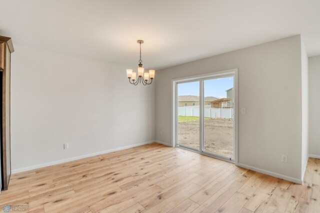 3445 18th St S, Moorhead, MN 56560 - spare room with baseboards, an inviting chandelier, and light wood-style flooring