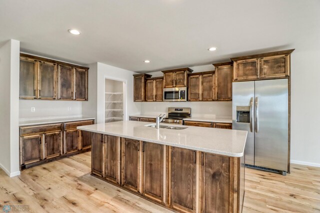 3445 18th St S, Moorhead, MN 56560 - kitchen with appliances with stainless steel finishes, a center island with sink, a sink, recessed lighting, and light wood-style flooring