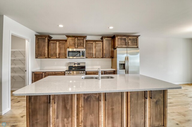 3445 18th St S, Moorhead, MN 56560 - kitchen featuring stainless steel appliances, baseboards, an island with sink, and a sink