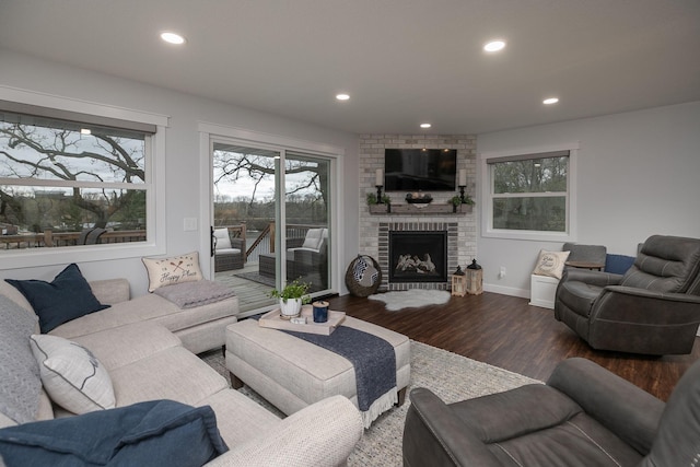 living room with a healthy amount of sunlight, a brick fireplace, recessed lighting, and wood finished floors