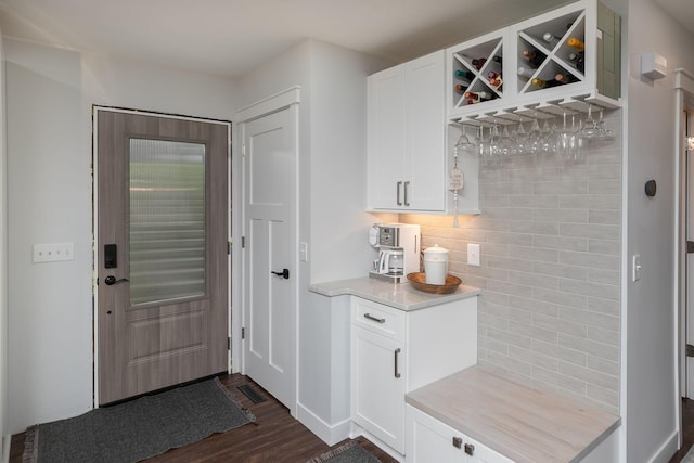mudroom with baseboards, a bar, dark wood-style flooring, and visible vents