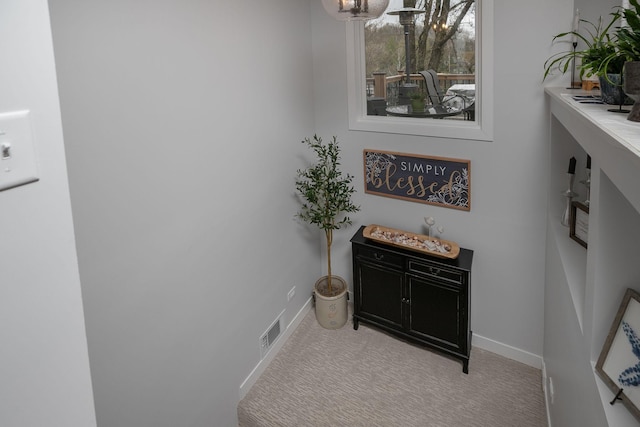 interior space with carpet flooring, baseboards, and visible vents
