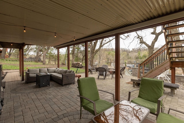 view of patio / terrace featuring stairway and an outdoor living space with a fire pit