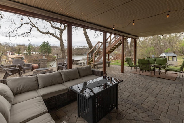 view of patio / terrace featuring a water view, outdoor lounge area, and stairway