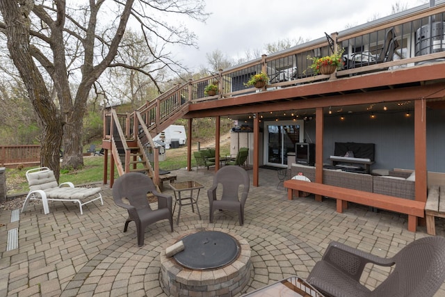 view of patio with fence, an outdoor living space with a fire pit, stairs, and a deck