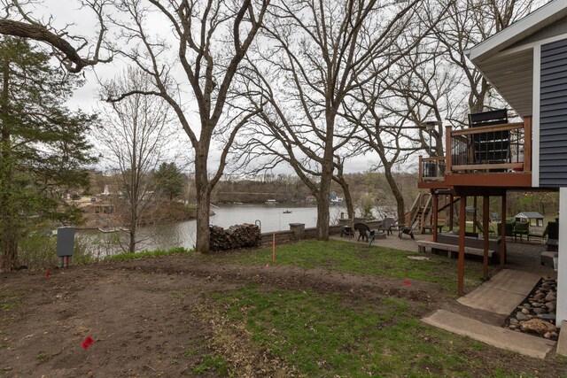 view of yard featuring a deck with water view and stairs