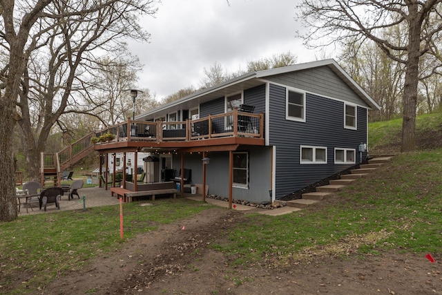 rear view of house with stairs, a fire pit, a wooden deck, and a patio