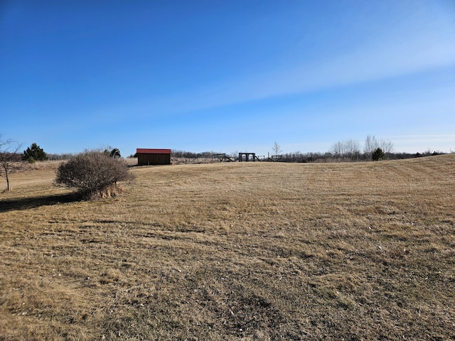 view of yard featuring a rural view and an outdoor structure