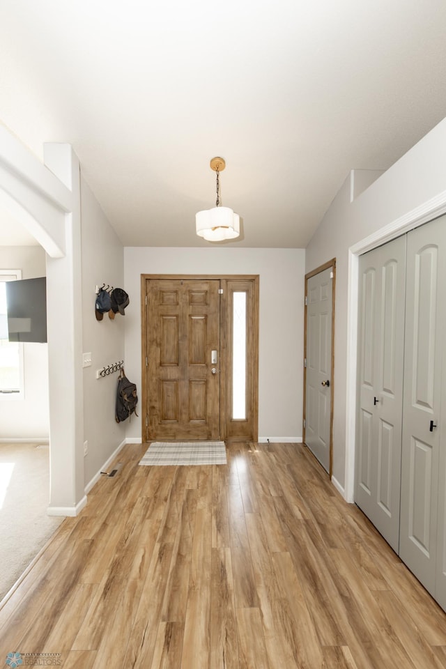 entryway with light wood-type flooring and baseboards