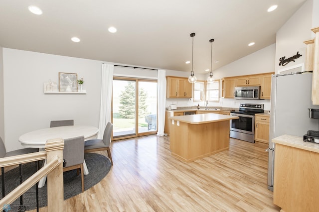 kitchen featuring a kitchen island, light brown cabinets, light countertops, vaulted ceiling, and stainless steel appliances