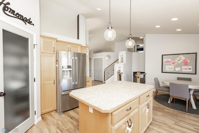 kitchen with stainless steel fridge, light countertops, light wood-style floors, and light brown cabinetry