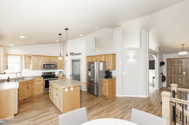 kitchen with light brown cabinetry, appliances with stainless steel finishes, a sink, a center island, and lofted ceiling