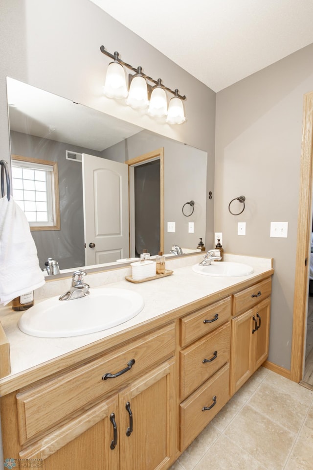 full bath with double vanity, a sink, and tile patterned floors