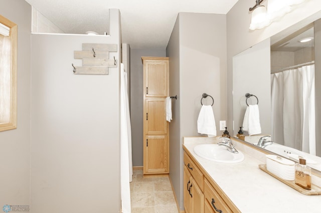 full bath featuring vanity, baseboards, and curtained shower