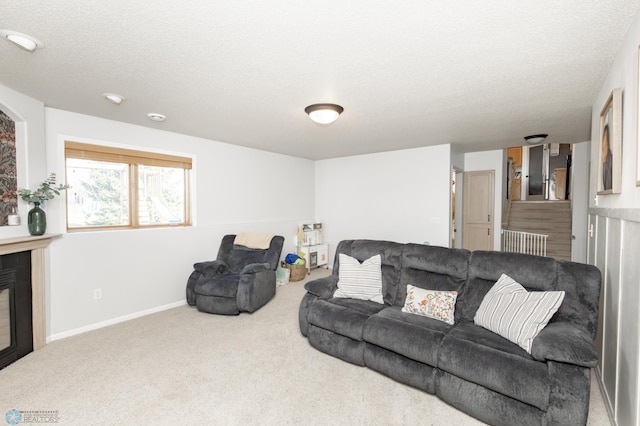 living area with carpet flooring, a textured ceiling, and baseboards