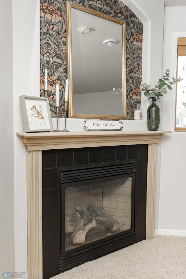 interior details with baseboards and a tile fireplace