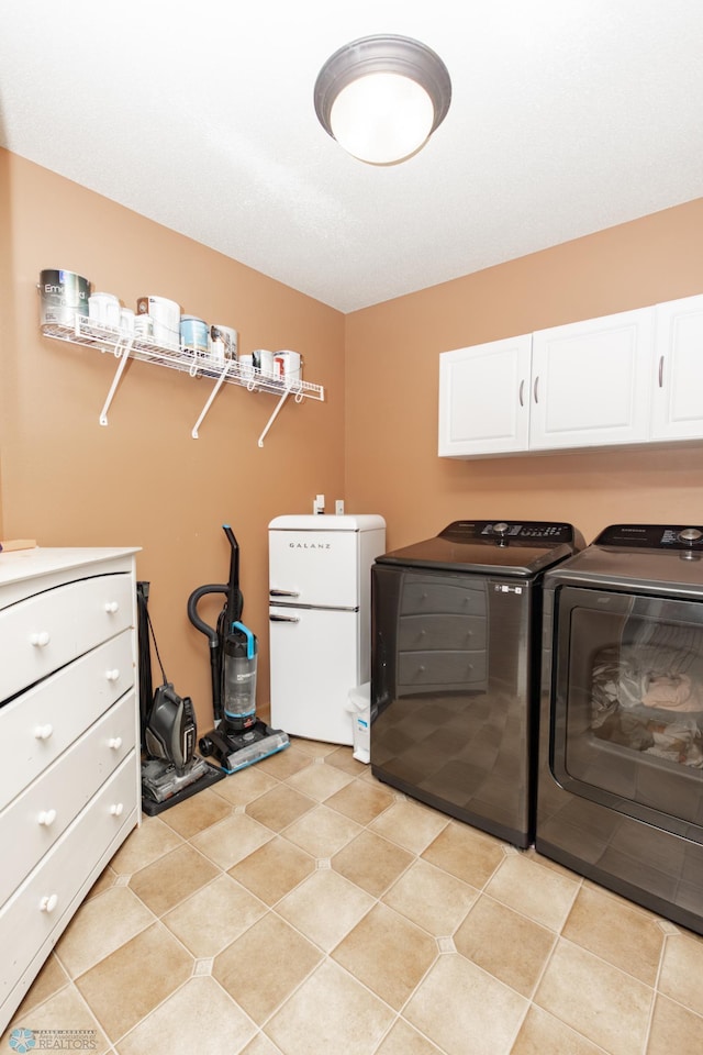 laundry room featuring separate washer and dryer and cabinet space