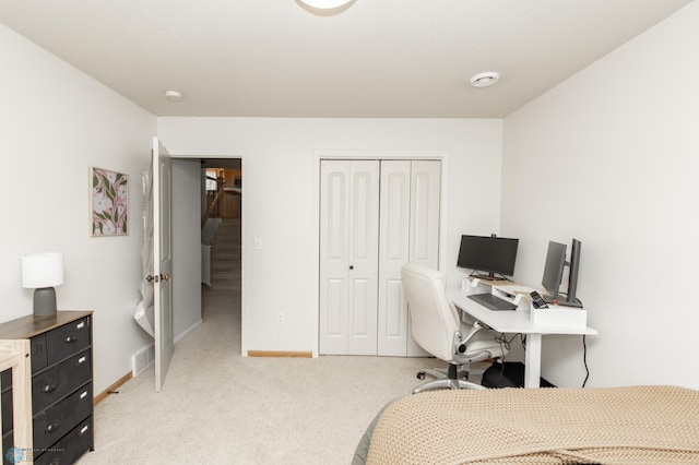bedroom featuring baseboards, visible vents, a closet, and light colored carpet
